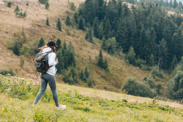 Naklejka na ściany i meble woman with backpack hiking in mountains