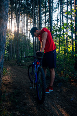 Naklejka premium Portrait of a handsome mountain biker drinking water while wearing his baseball cap (hat).