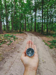 woman hand holding compass in forest