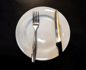 The forks and knives that are on the plate