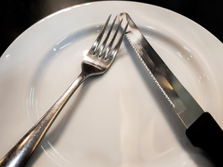 The forks and knives that are on the plate