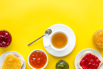 Tea party with jam. Toast, teapot, cup on yellow background copy space
