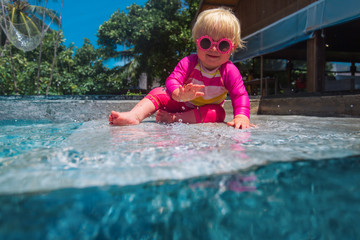 cute little girl play with water in swimming pool