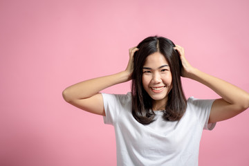 Fototapeta premium Portrait of a happy girl showing a gesture on a pink background