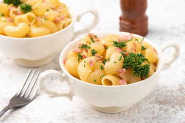 macaroni cheese with bacon on white backdrop 