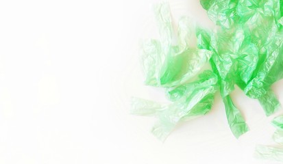 A pile of plastic bags on a white background. The concept of pollution with plastic waste, stop using plastic, an environmentally friendly lifestyle. Top view, copy space for text.