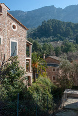 Blick über grünes Tal und mallorquinische Häuser in Fornalutx auf spanischer Baleareninsel Mallorca im Frühling