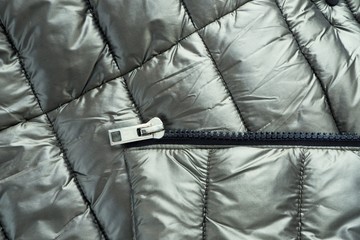 Close-up zipper closure on a light warm olive-colored jacket. Warm clothes, accessories for outerwear. © Smart Blonde 