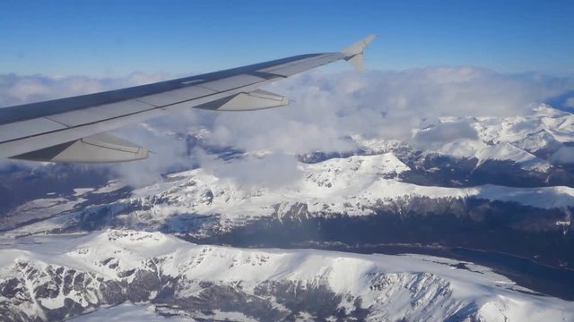 Scenic view from from POV airplane flight window of Cordillera de los andes with snow on top of mountains before landing at the airport of Ushuaia, Argentina in Tierra del Fuego province