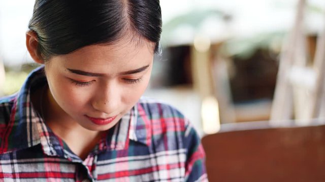 Close up face of asian woman hand holding mobile phone while using application.
