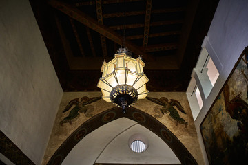 View of a chandelier hanging off the ceiling of the interior of a historical Spanish style building in California