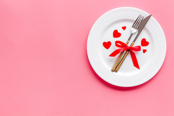 Valentines day table. Plate on pink background top-down copy space