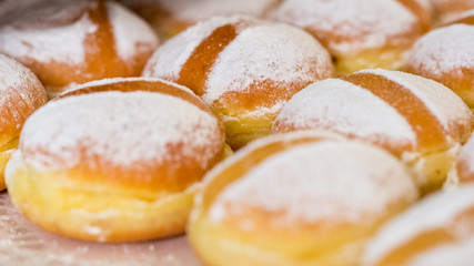 VIENNA, AUSTRIA - Jan 31, 2020: Close up of austrian Krapfen (english: doughnuts). Fried, with powdered sugar on top. Popular food in german speaking countries. Also known as Berliner. Sweet pastry.