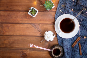  coffee cup on a wooden table, cinnamon, warm blanket, cozy photo, flat lay