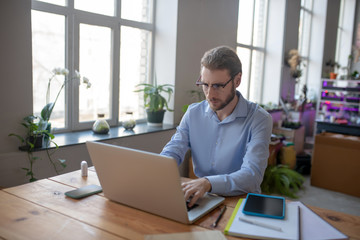 Fototapeta na wymiar Young man working on laptop in office.