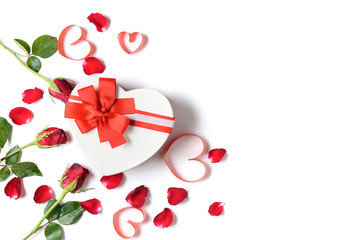 Heart gift box and red roses with heart red ribbon and rose petals