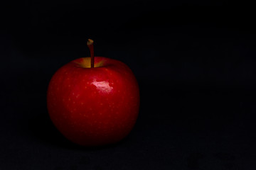 red apple on black background