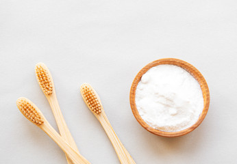 Wooden bamboo eco friendly toothbrushes, baking soda  on white background. Dental care and zero waste concept