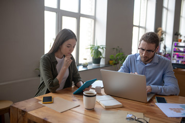Man and girl sitting at a table in the office.