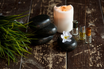Massage stones and candle close-up on a wooden dark background