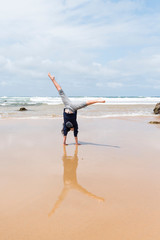 Child doing handstands at the beach at Phillip Island, Victoria Australia