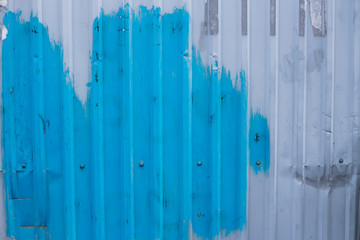 Old rusty metal fence construction for grunge background in design.  Abstract grungy blue and grey backdrop. Dirty smudge and damaged surface. Textured industrial  aluminum board  outside the street
