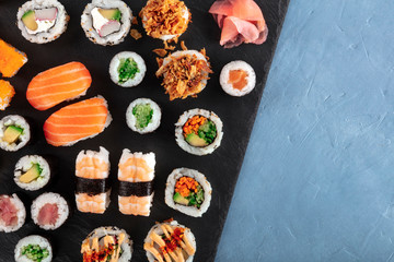 Large sushi set, shot from the top with a place for text. A flat lay of various maki, nigiri and rolls