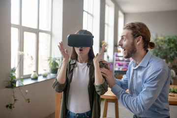 Man and woman enjoying using VR glasses