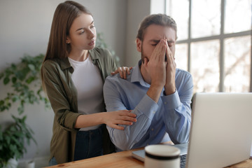 Attentive woman supporting her upset male colleague