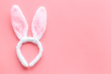 Easter bunny concept. Toy rabbit's ears for head on pink background top-down copy space