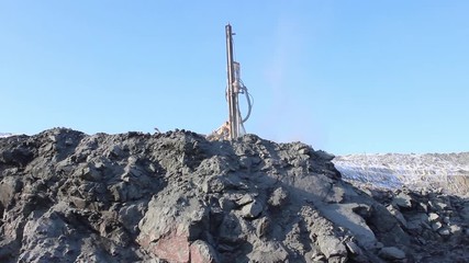 The drilling rig does its job in an open pit. Drill is drilling. - Powered by Adobe