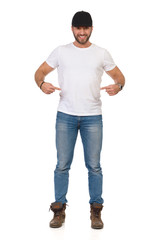 Young Man In Jeans, White T-shirt And Black Cap Is Pointing At Himself And Smiling