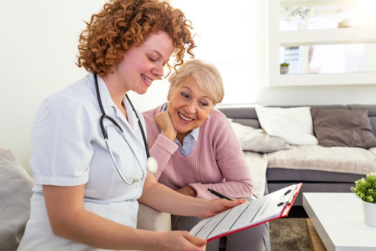 Young doctor filling up medical record with her patient. Health care form Medical doctor discusses with patient about the health examination results, happy senior patient with her doctor