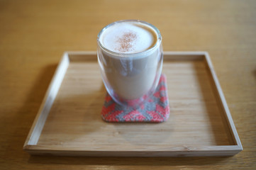 Close up hot coffee  latte in transparent glass on timber table