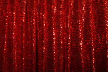 red drapery made of bright shiny fabric with round pleats hanging in folds