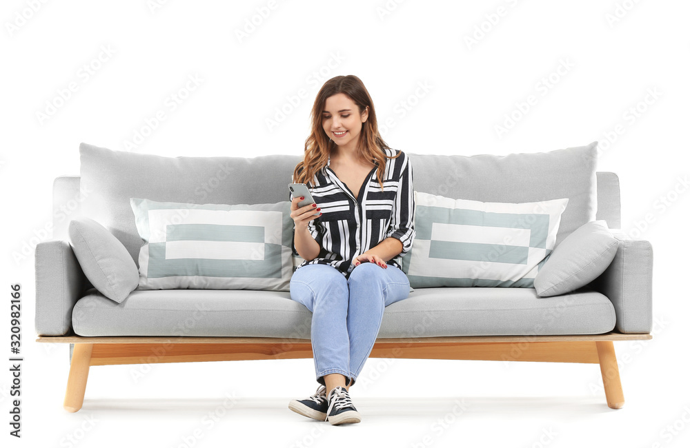 Canvas Prints young woman with mobile phone sitting on sofa against white background