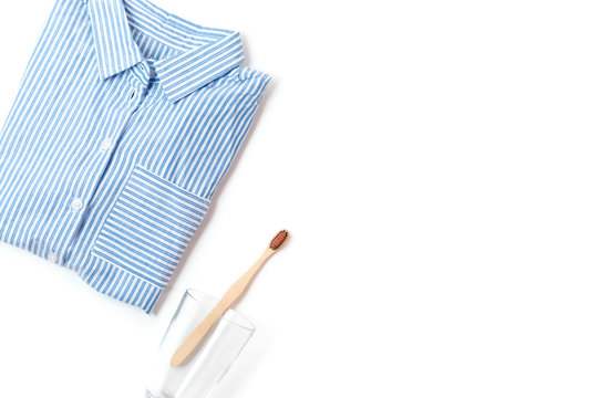 pajamas shirt and wooden toothbrush on a white background