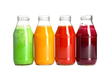 Bottles of fresh vegetable juices on white background