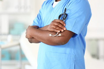 Male African-American nurse with stethoscope in clinic