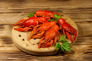 Boiled crayfish on cutting board on wooden table