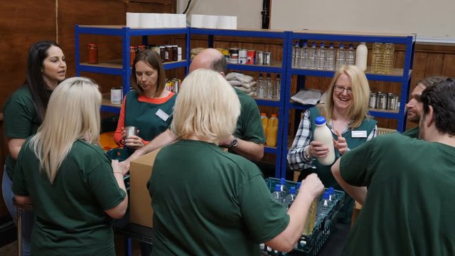 Group of Food Bank volunteers help to sort tinned food for people in poverty and hungry