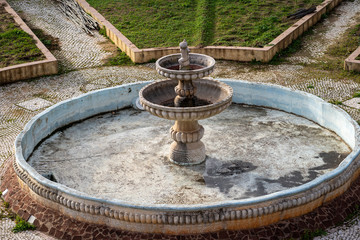 Rusty old fountain, drained of water, in a courtyard - Silves Portugal