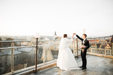 Beautiful wedding couple dancing on a balcony