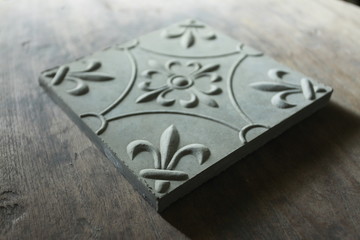 Floor tiles embossed with floral motifs. Gray blend with the color of the rocks suitable for outdoor