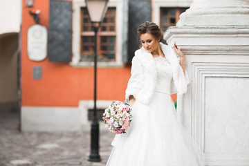 Naklejka premium Beauty portrait of bride wearing fashion wedding dress with feathers with luxury delight make-up and hairstyle