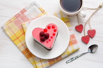 souffle cake in the shape of heart  with cup of coffee on a wooden table