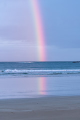 Rainbow over the ocean with clouds