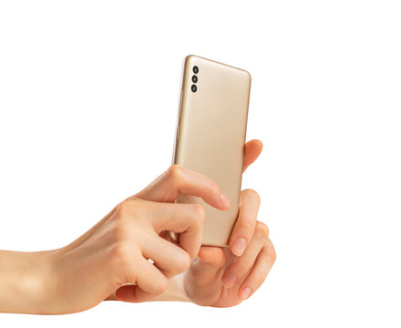  Female hands take a photo on a golden smartphone with three cameras on a white background.