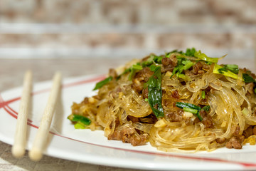 Ants climbing a tree. This is the name of a classic dish of Chinese and Sichuan cuisine. In a traditional recipe, minced pork is styr-fried with noodles and spices.  The dish is served with herbs.