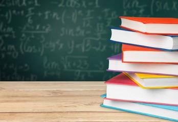 Colorful books collection on wooden desk.